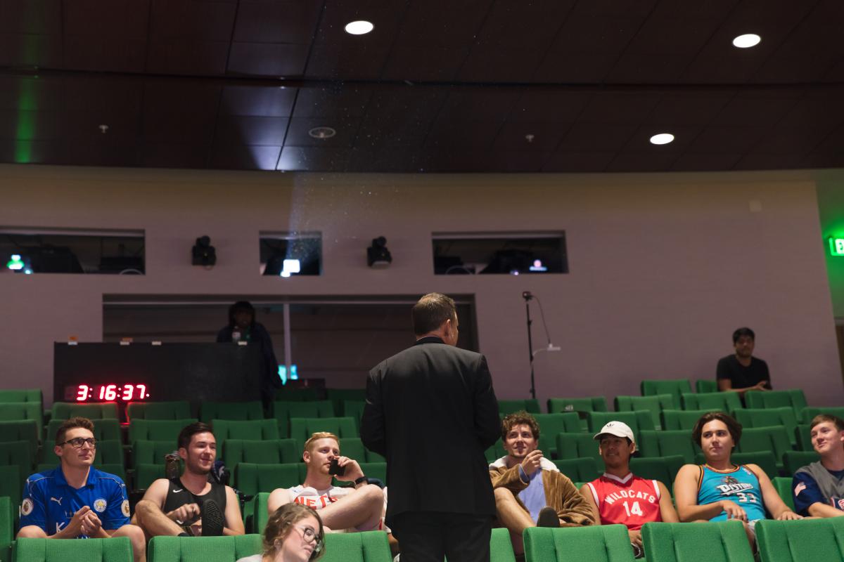 man facing a group of people sitting in chairs