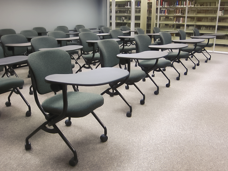 rows of empty black mobile chairs with swivel arm