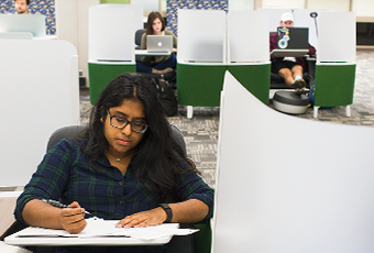 three students in green and white individual study pods